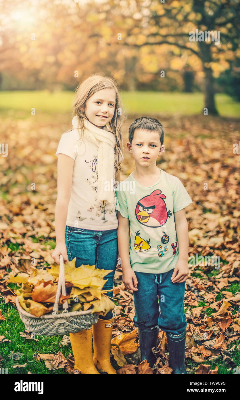two siblings standing in autumn park Stock Photo