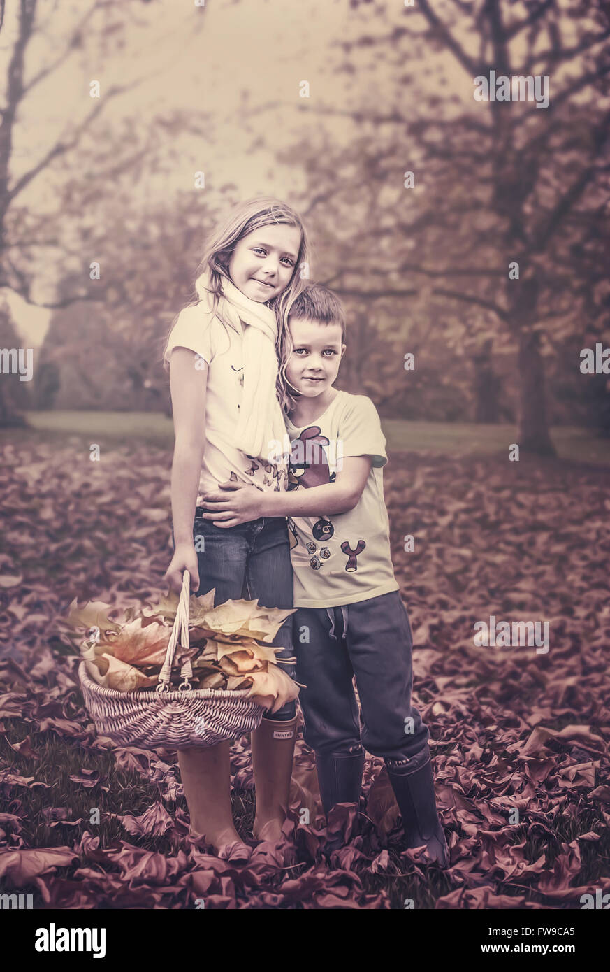 two kids in autumn park holding each other Stock Photo