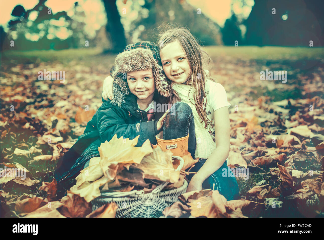 two kids in autumn leaves Stock Photo