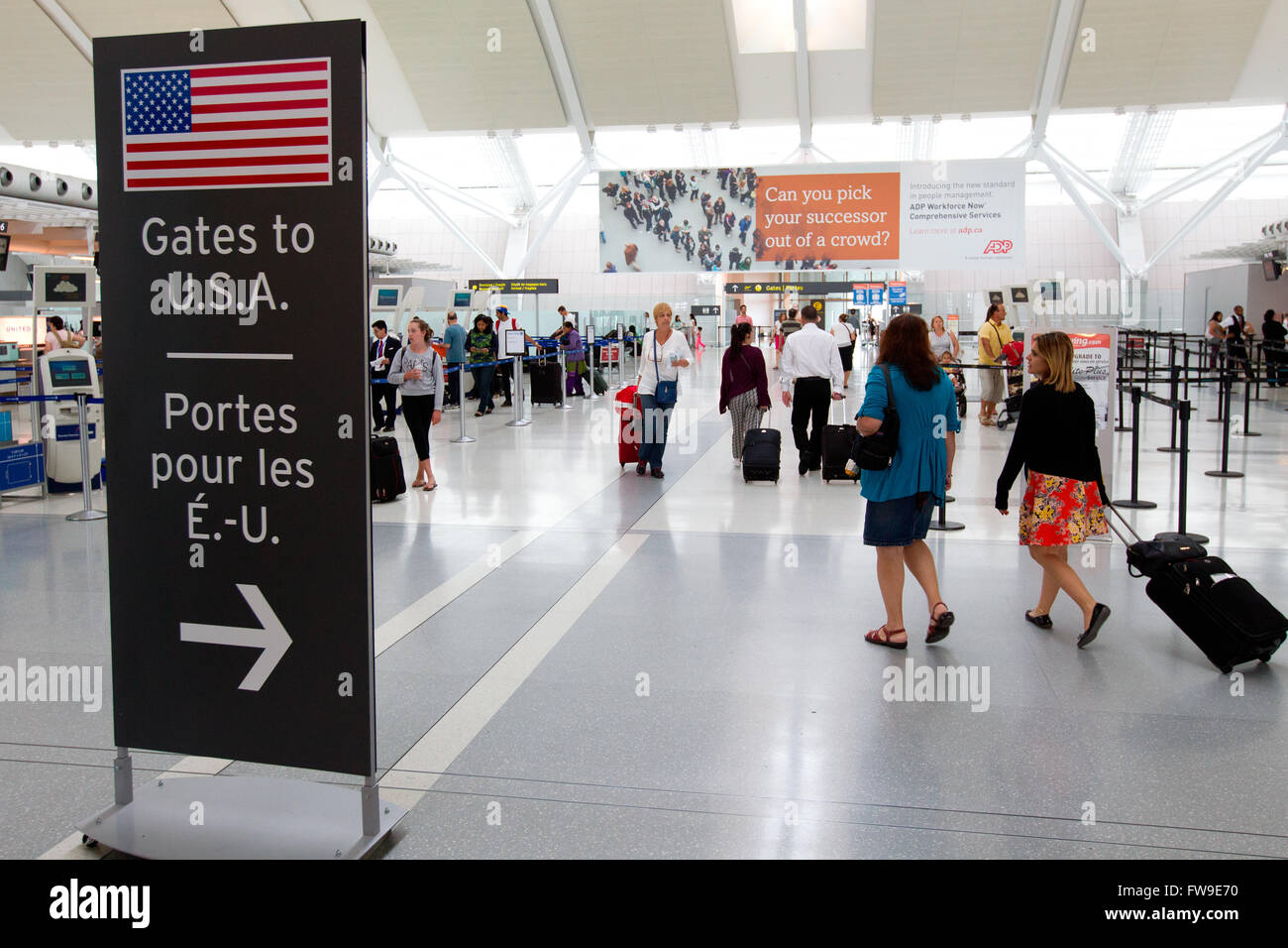 People walk toward the checked gate for flights to the U.S at terminal 1 at Pearson International airport in Toronto, Ont., on T Stock Photo