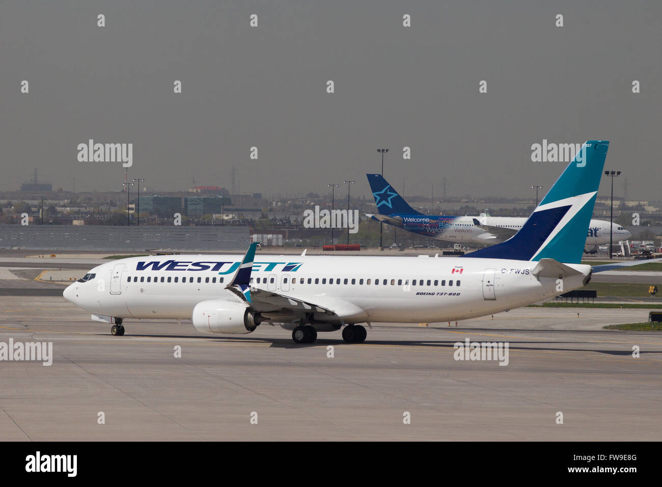 A Westjet aircraft waits to be loaded before departing from Pearson International airport in Toronto, Ontario on May 7, 2015. Stock Photo