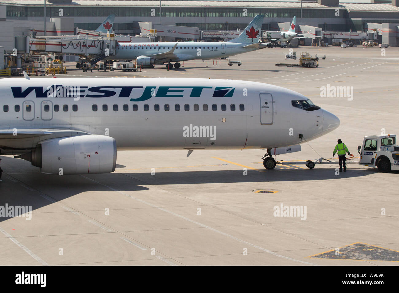 A Westjet aircraft waits to be loaded before departing from Pearson International airport in Toronto, Ontario on May 7, 2015. Stock Photo