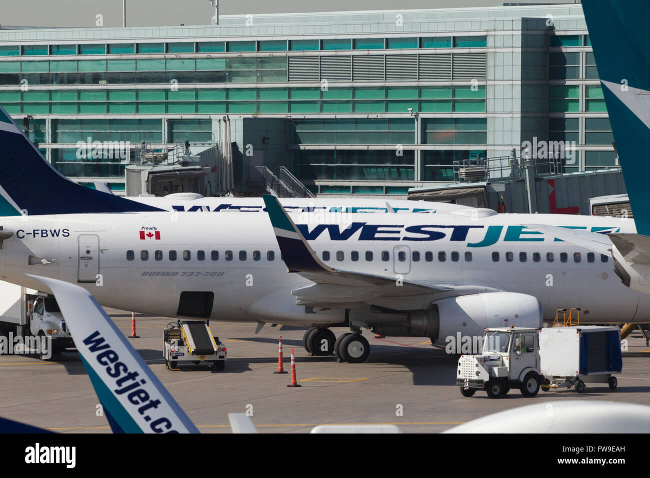 A Westjet aircraft waits to be loaded before departing from Pearson International airport in Toronto, Ontario on May 7, 2015. Stock Photo