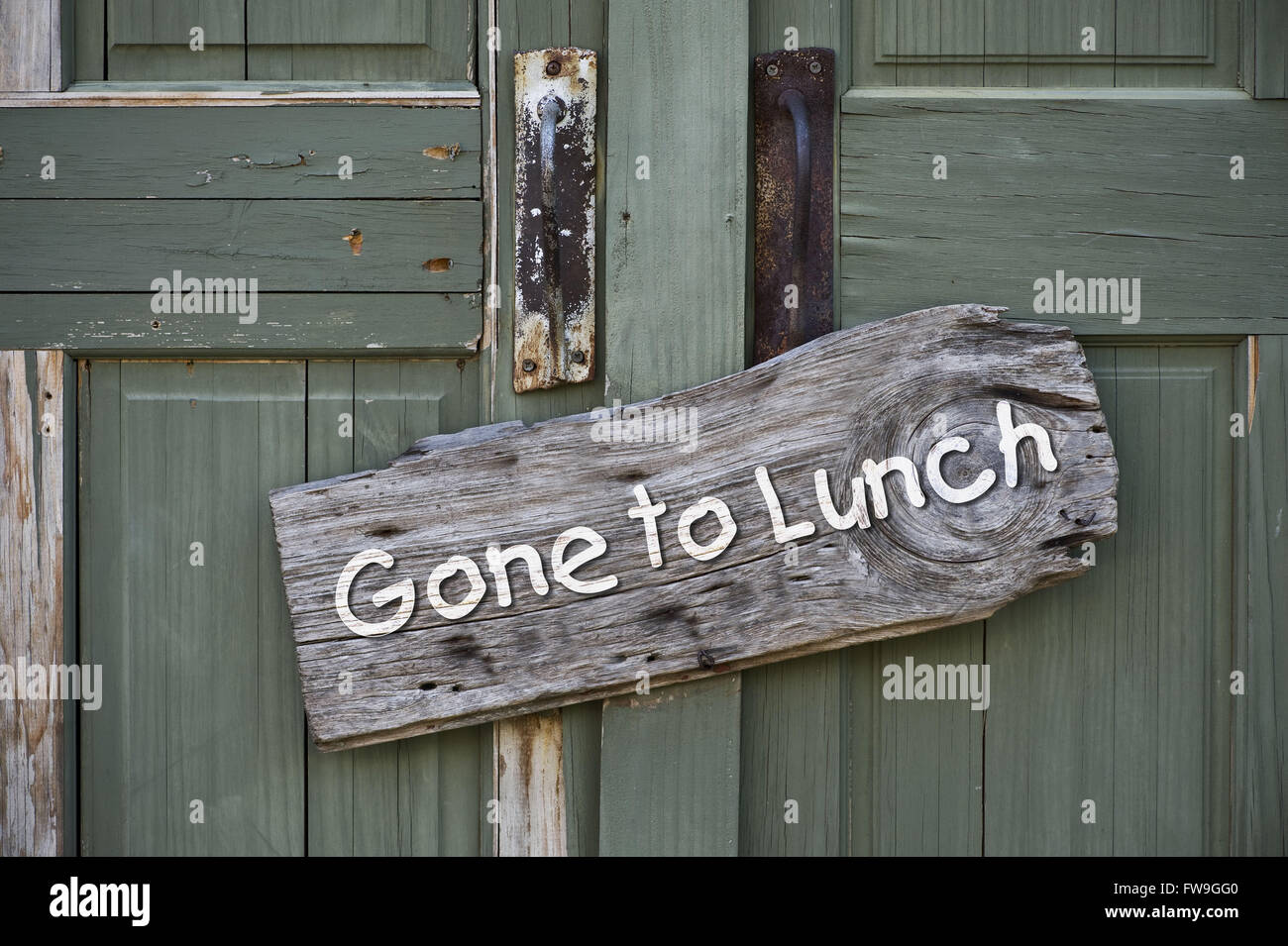 Gone to lunch sign on old green doors. Stock Photo