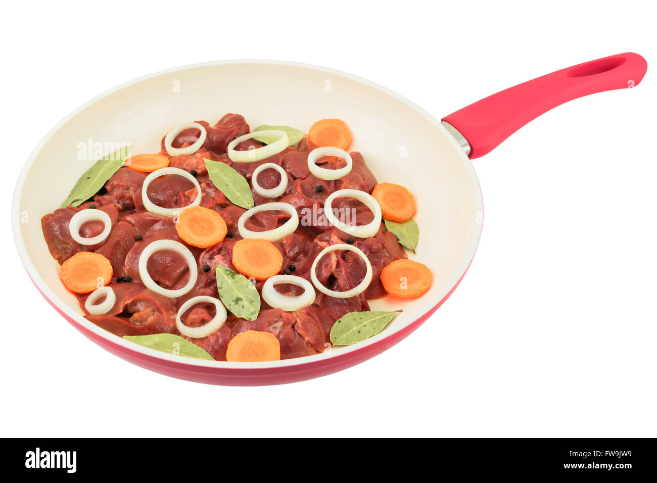 fresh chicken liver with carrot and onion slices, bay leaves and allspice in a white frying pan