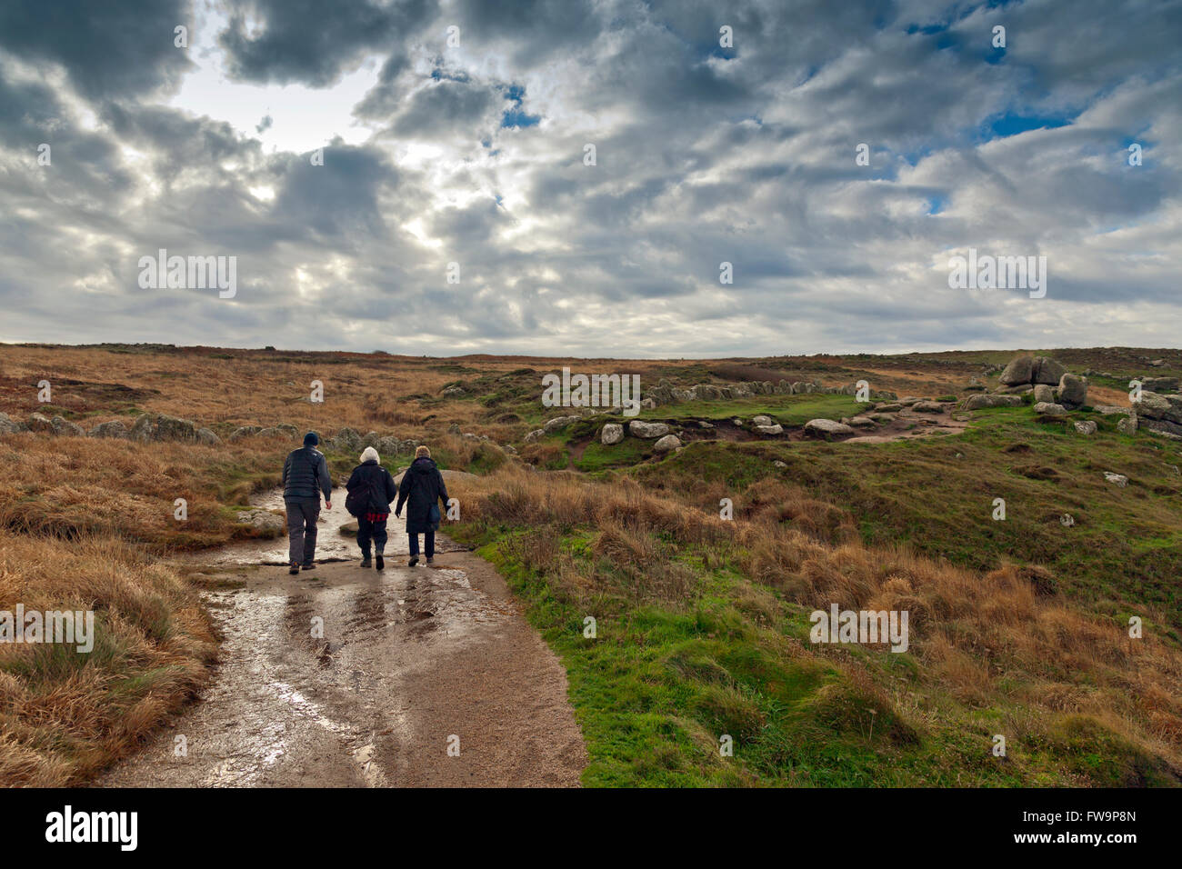 Three walkers on the SW Coast footpath between Land's End and Sennen Cove, Cornwall, England, UK Stock Photo