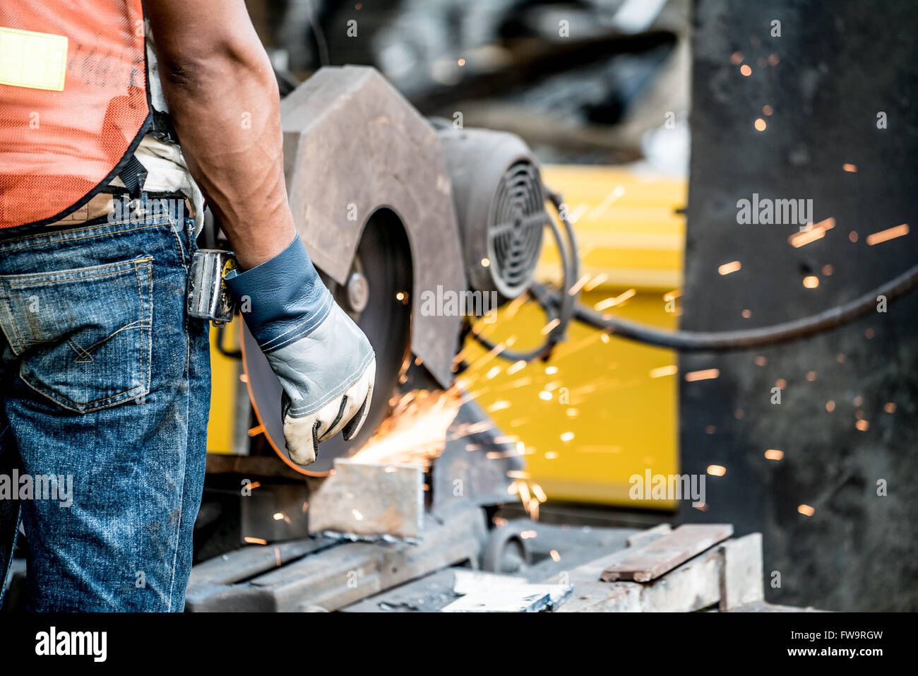 Technician or mechanic using metal grinder in factory, manufacturing industry concept Stock Photo