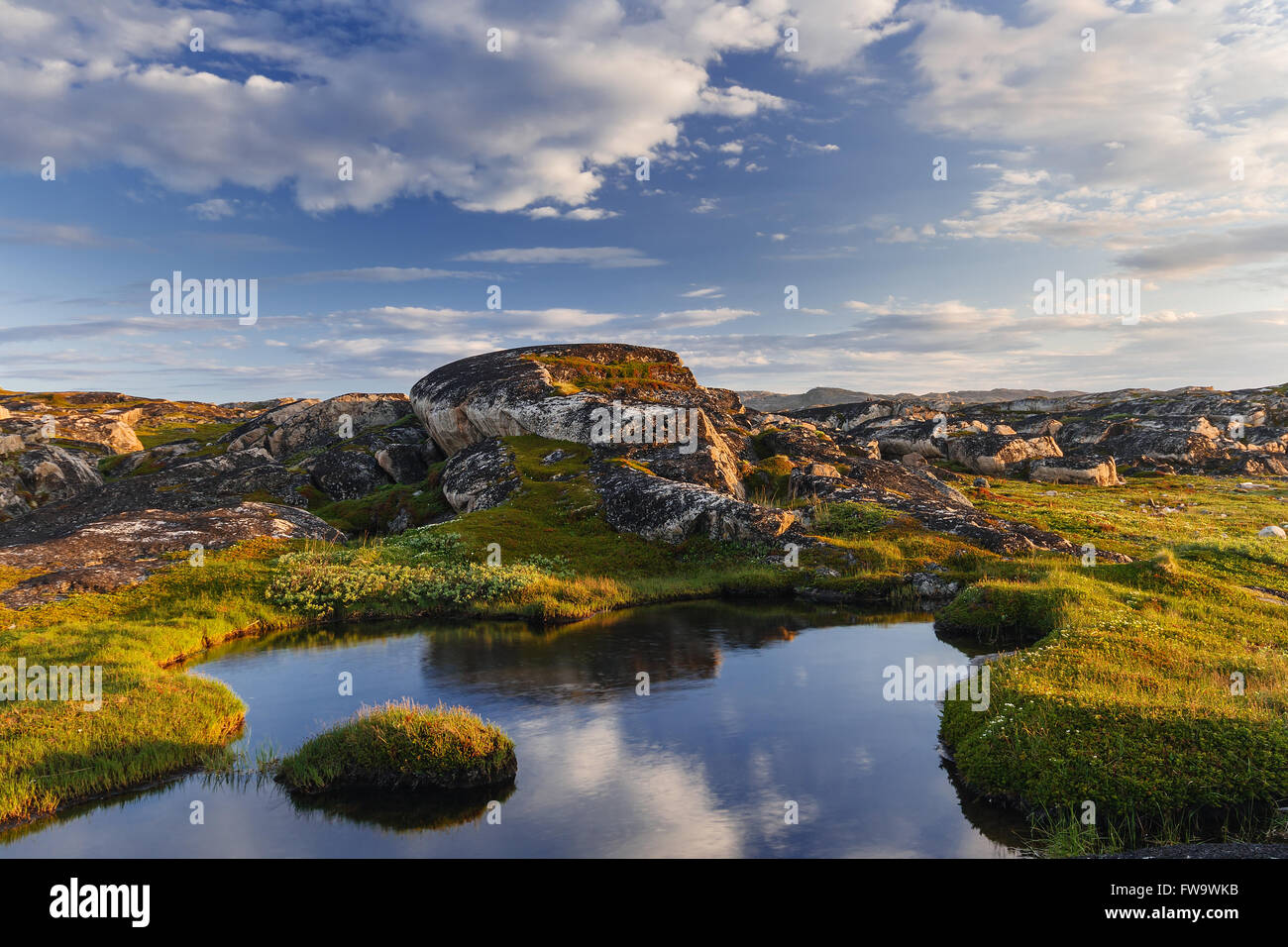 Small lake behind a polar circle lit with the northern summer sun Stock Photo
