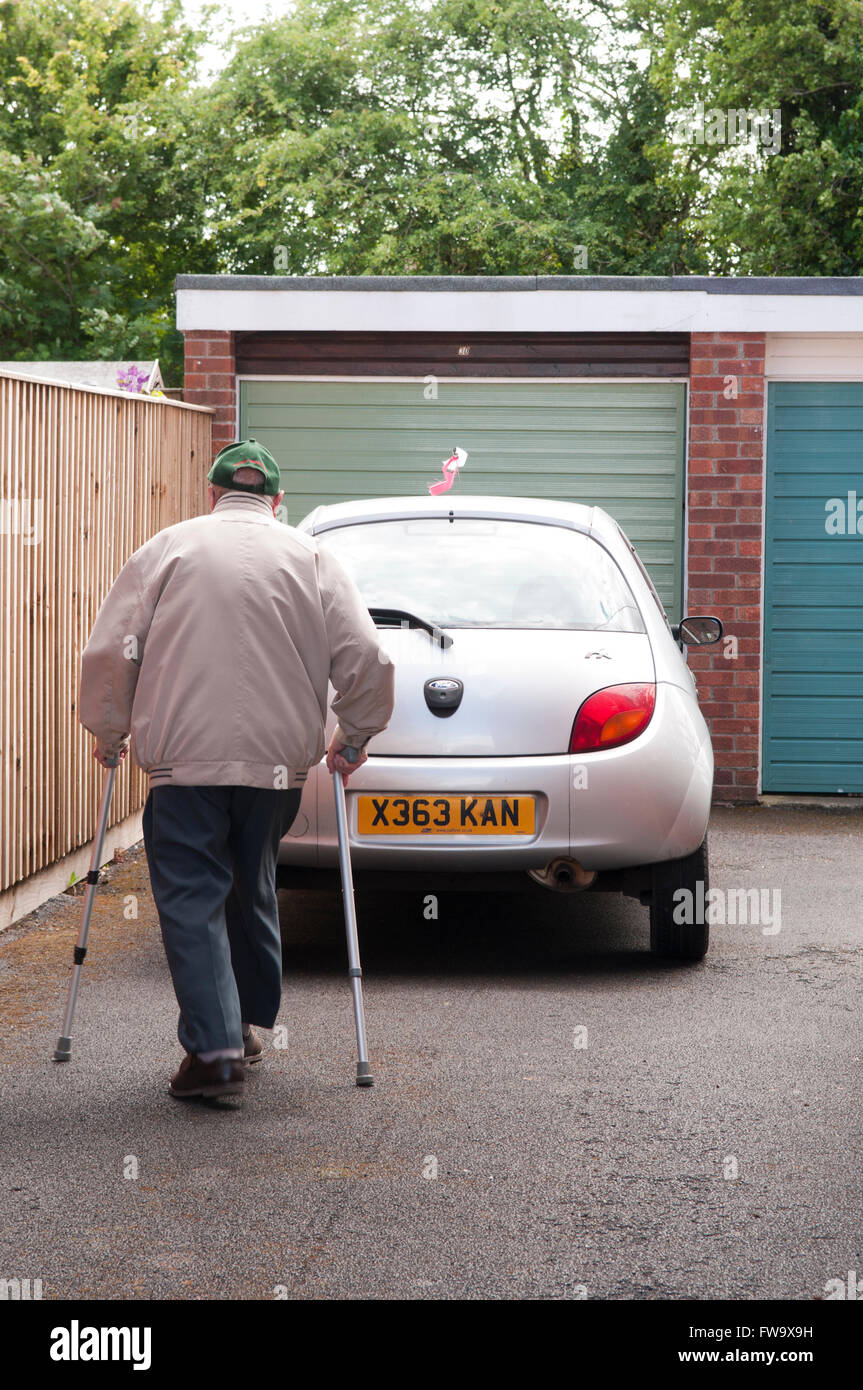 Rear view of an elderly man walking with two walking sticks Stock Photo ...