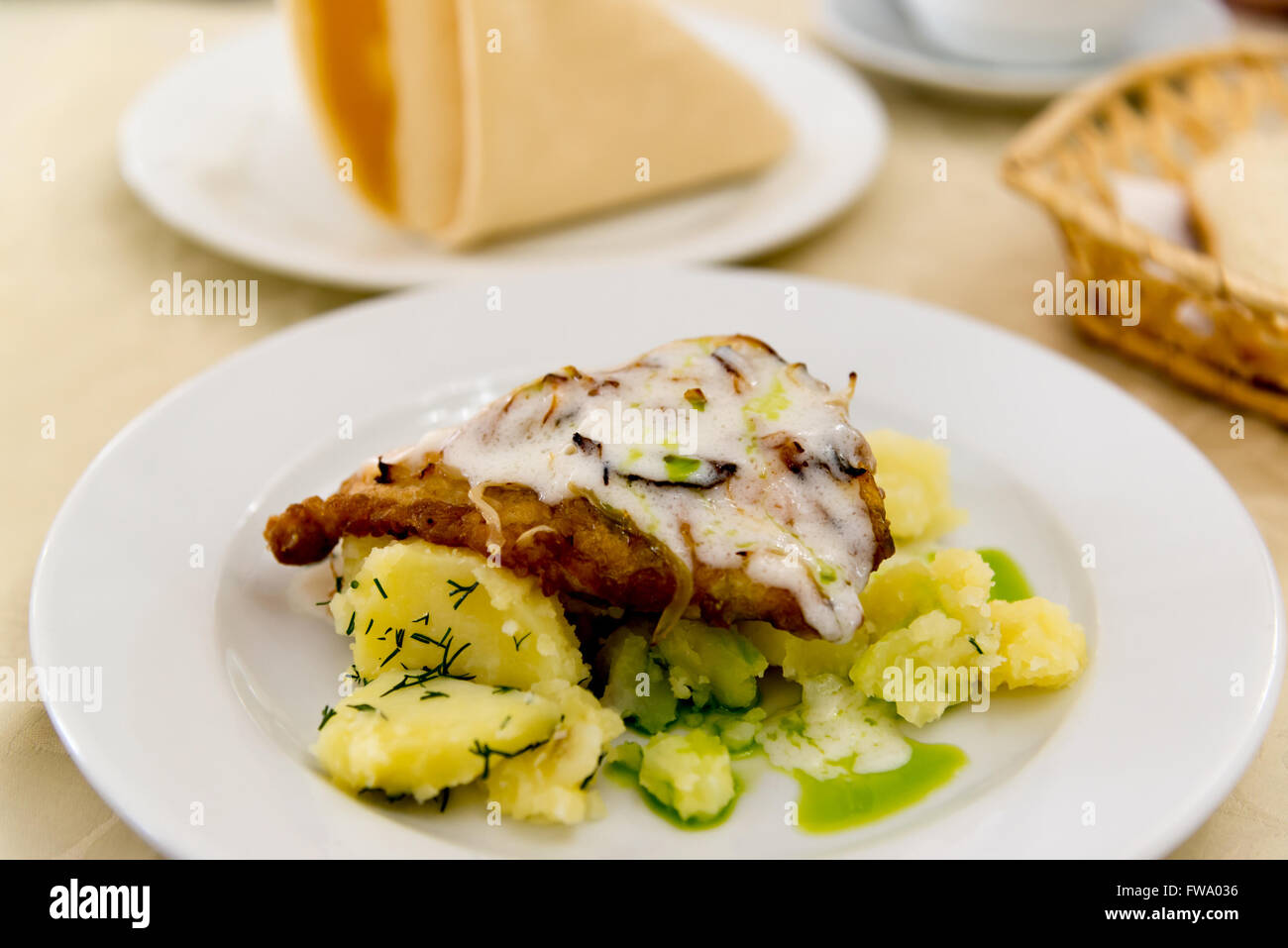 Boiled potatoes and cod in batter Stock Photo