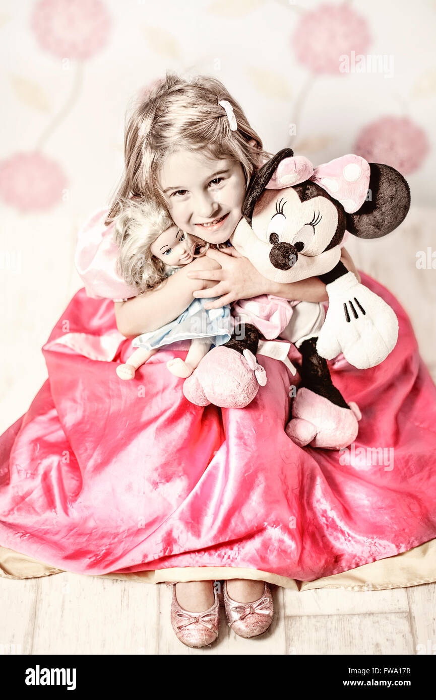 young girl wearing princess costume holding a mouse toy Stock Photo