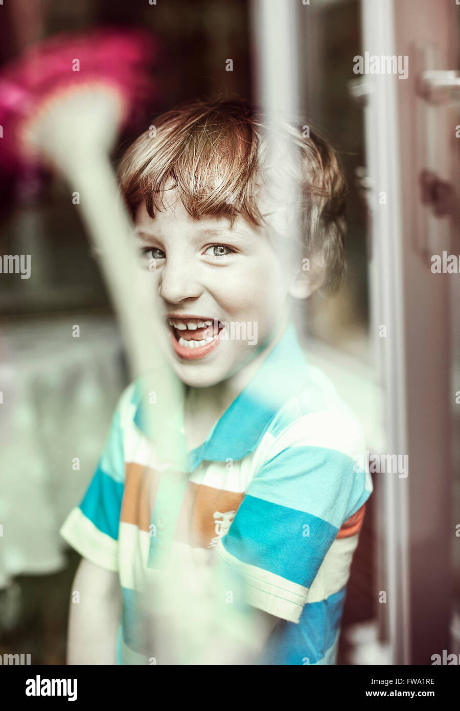 happy small boy standing by the window Stock Photo