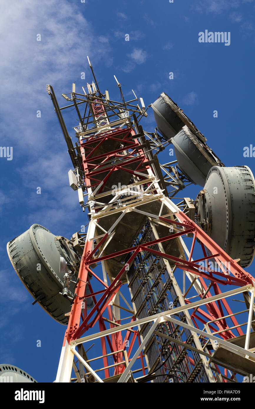 Telecommunications tower against blue sky, in red and white Stock Photo