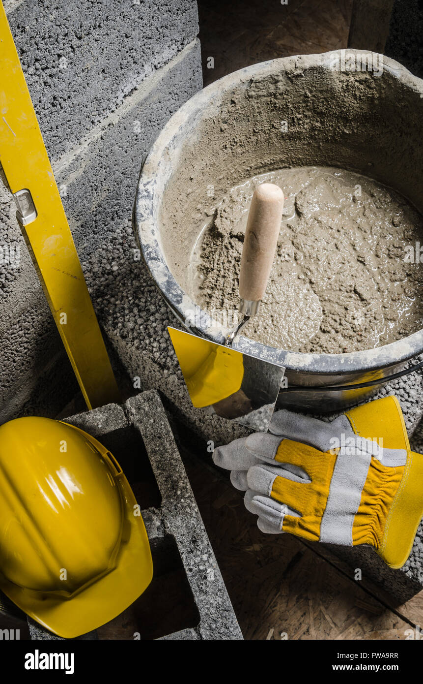 Tools for bricklayer bucket with a solution and a trowel, closeup