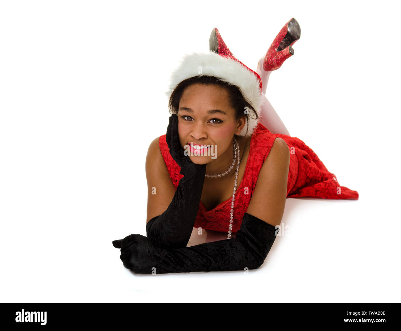 Smiling African Americcan Woman in Red Christmas Dress and Santa Hat ready for party. Stock Photo