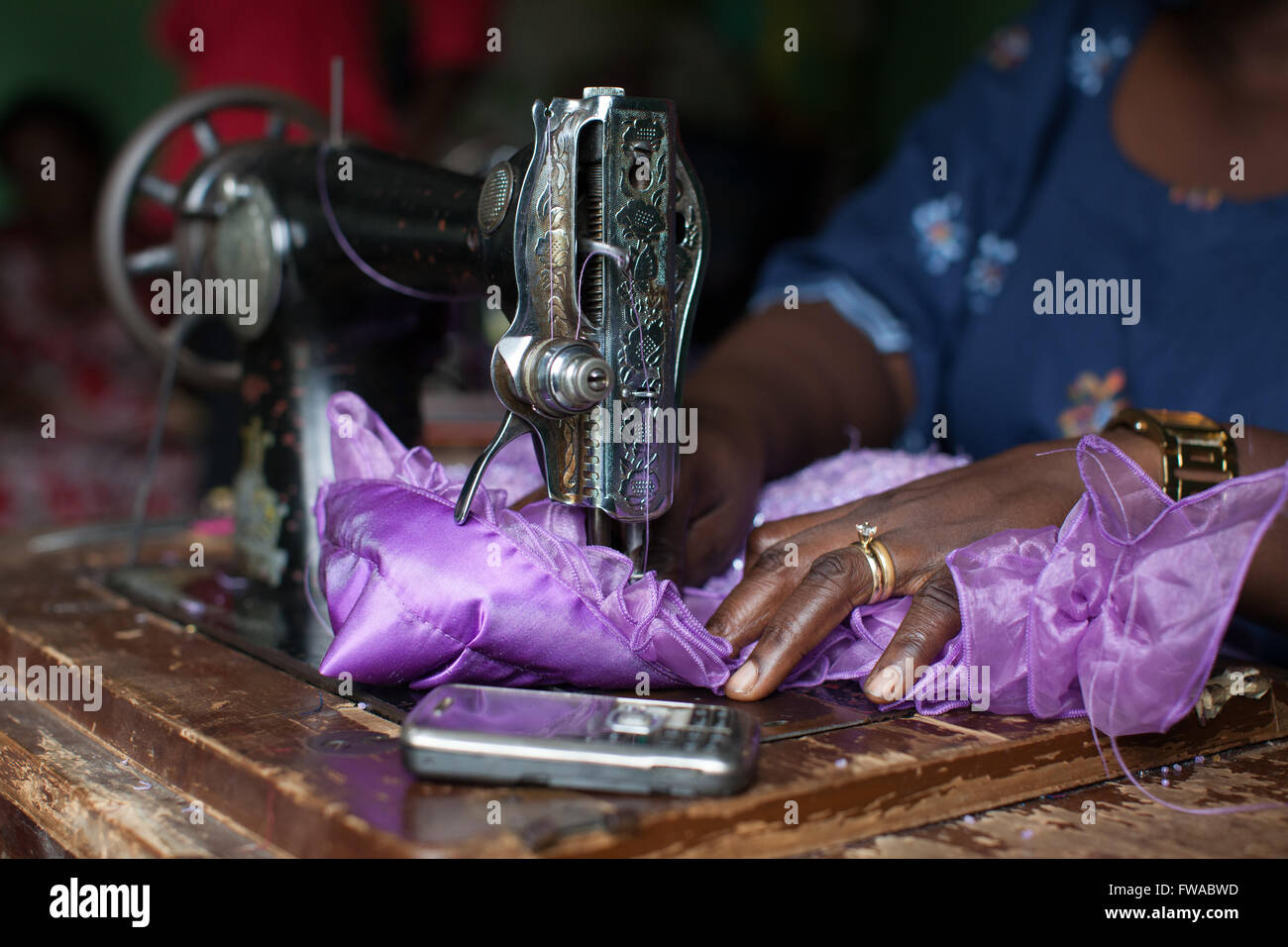 A female dress maker using a sewing machine, Nigeria, Africa Stock Photo