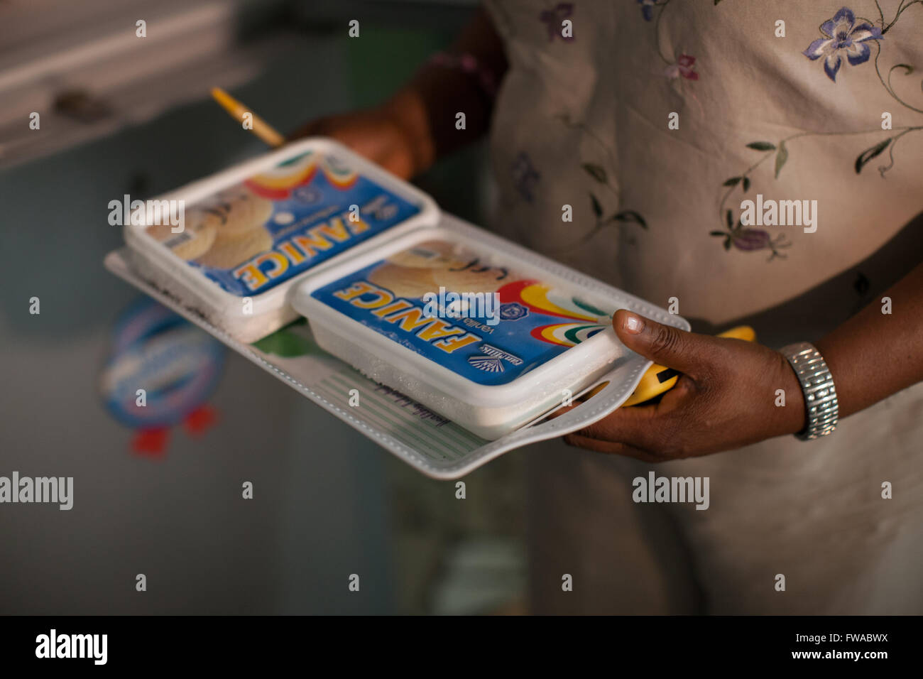 A woman carrying lids for the packages of frozen food sold in a local