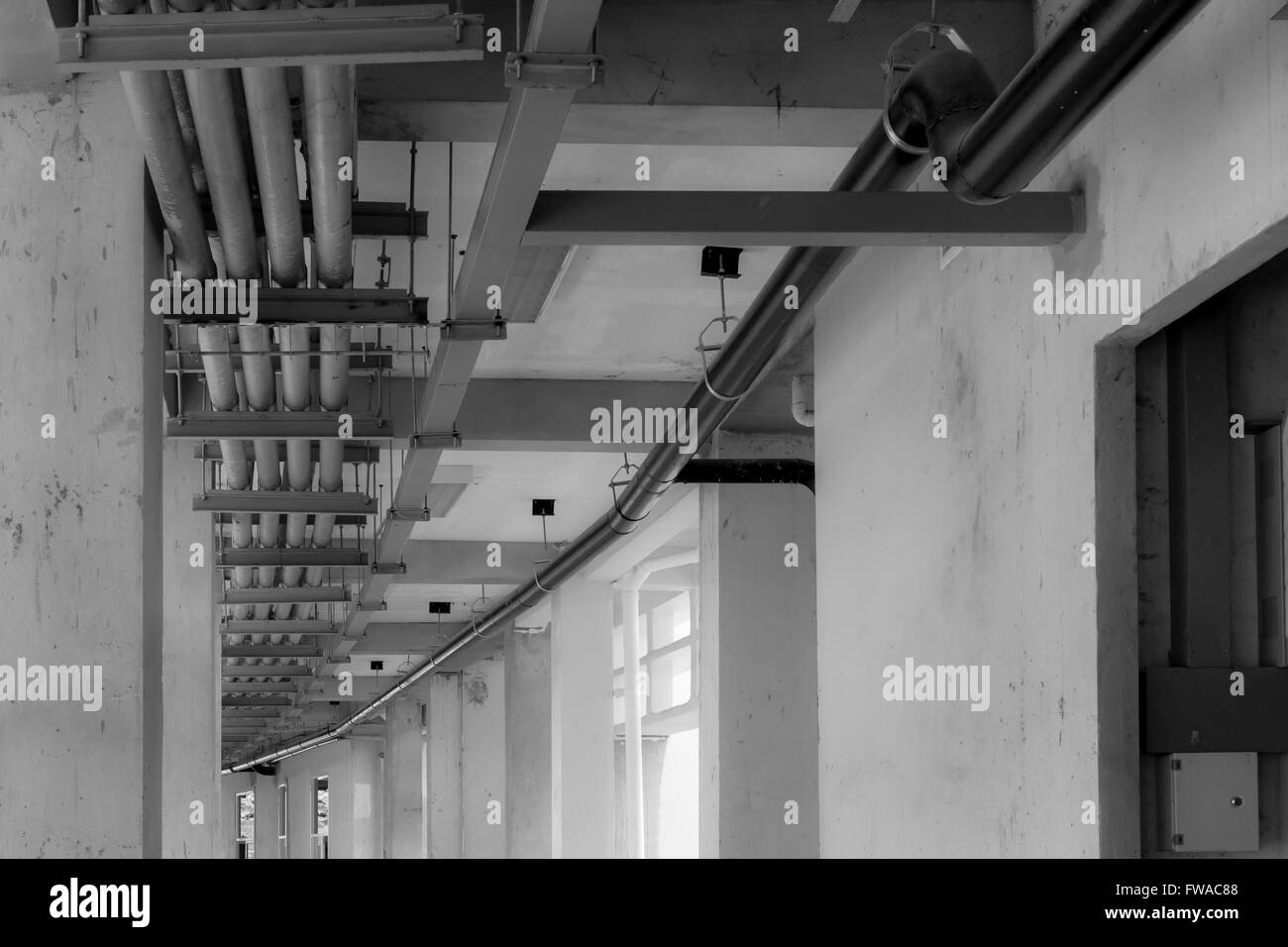 hanging water and fire pipes in construction site, black and white Stock Photo
