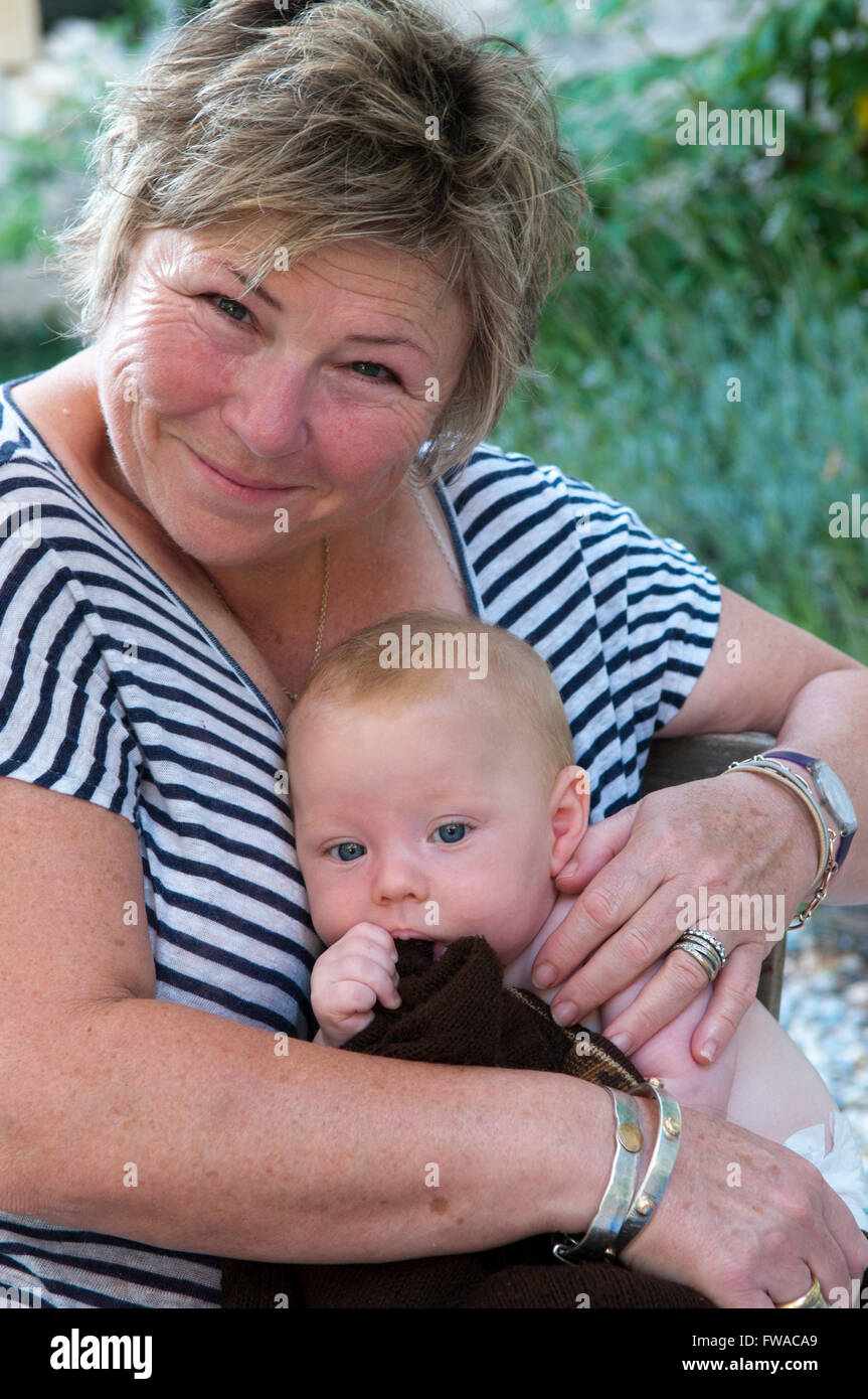 Baby being cuddled by mature woman Stock Photo