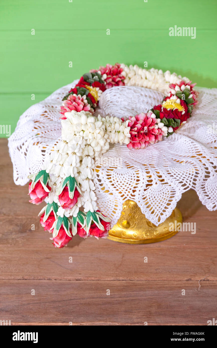 Jasmine garland at lace cloth enter phan on nature old wood Stock Photo