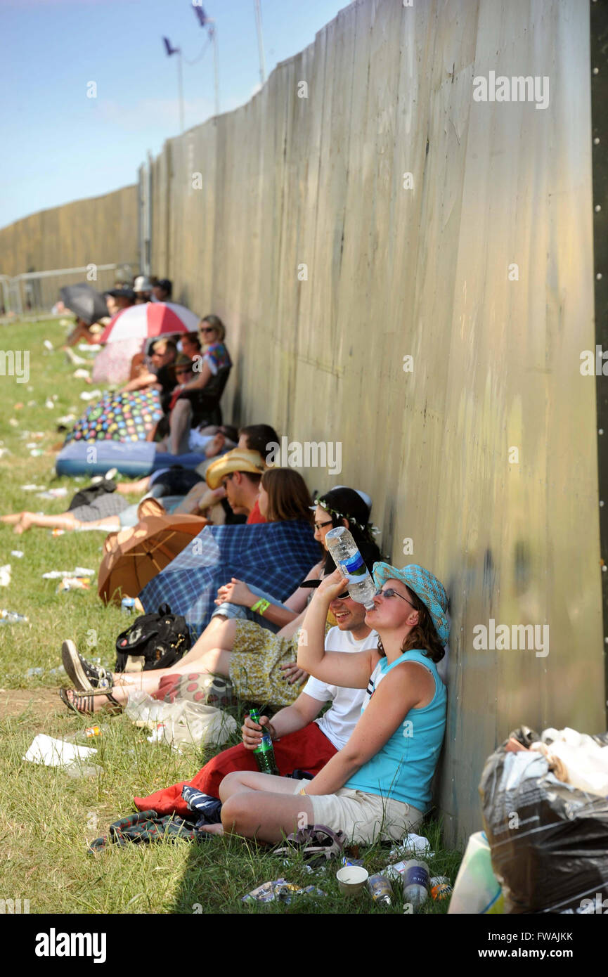 Revelers use any available shade at the Glastonbury Festival 2010, Pilton Somerset UK Stock Photo