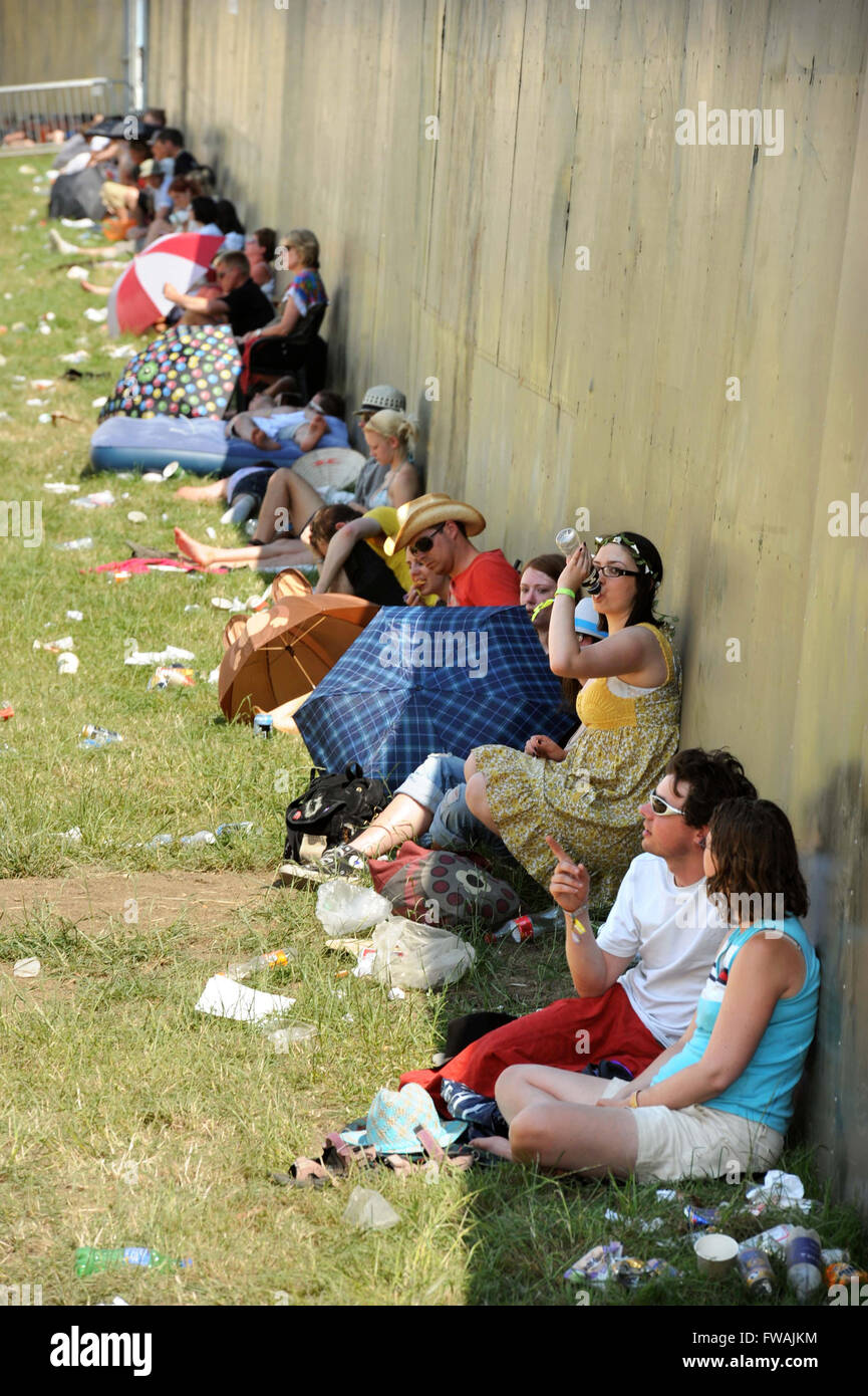 Revelers use any available shade at the Glastonbury Festival 2010, Pilton Somerset UK Stock Photo