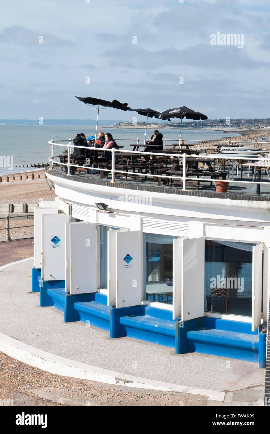 Customers sitting on the terrace balcony at the Marina Pavilion bar and restaurant in St Leonards-on-Sea, East Sussex Stock Photo