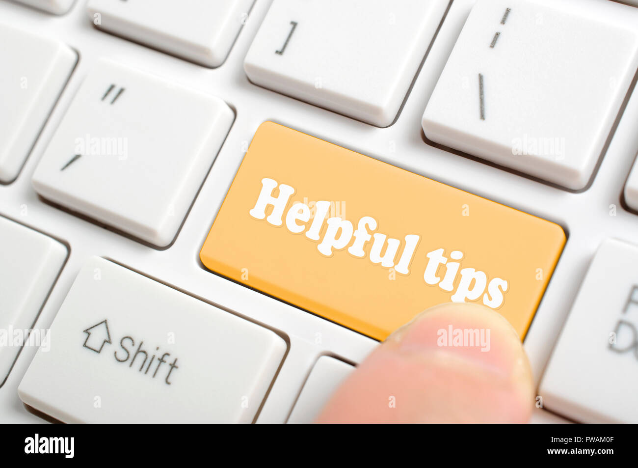 Pressing brown helpful tips key on keyboard Stock Photo