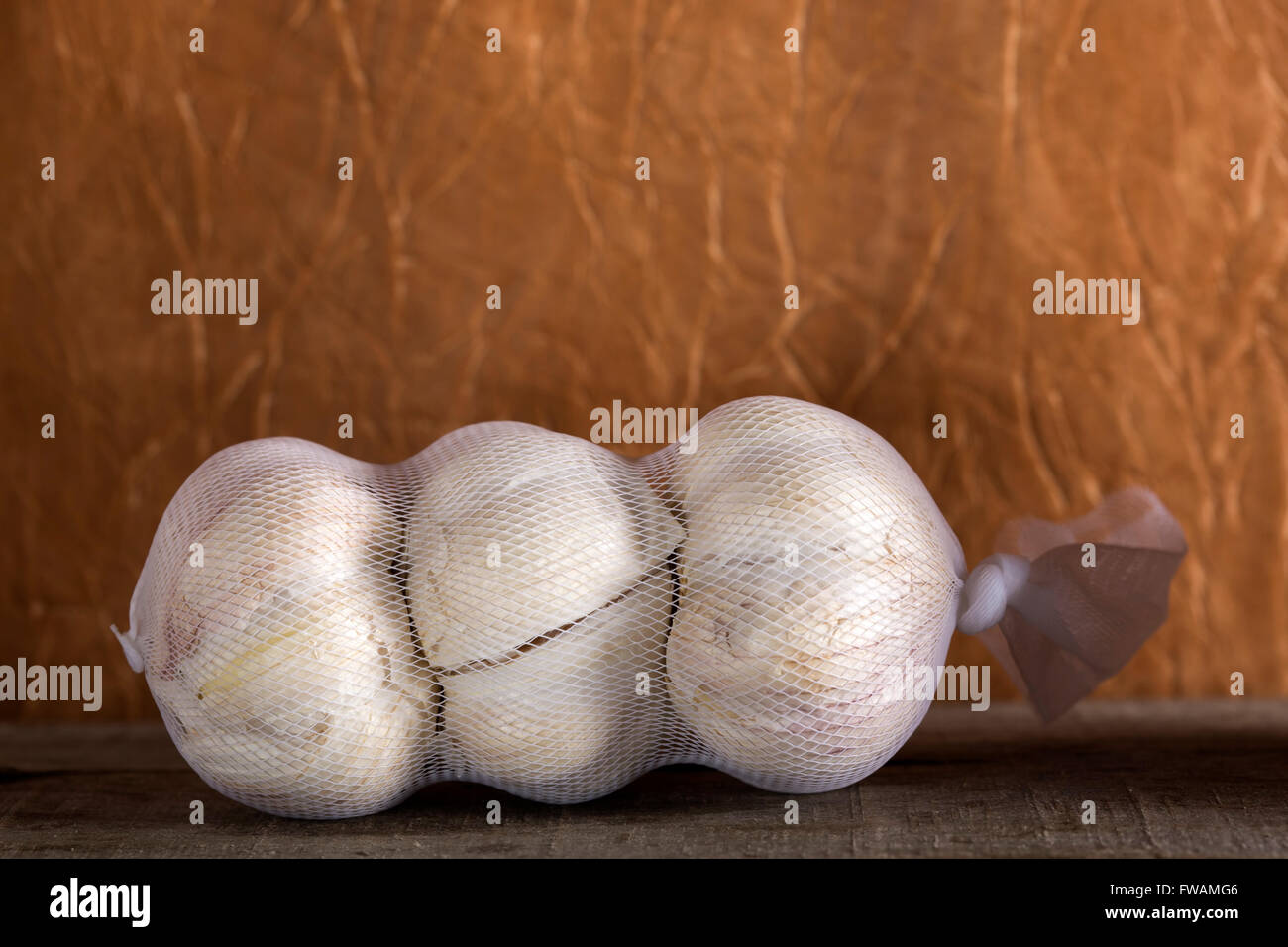 One packaged garlic over old wooden table Stock Photo