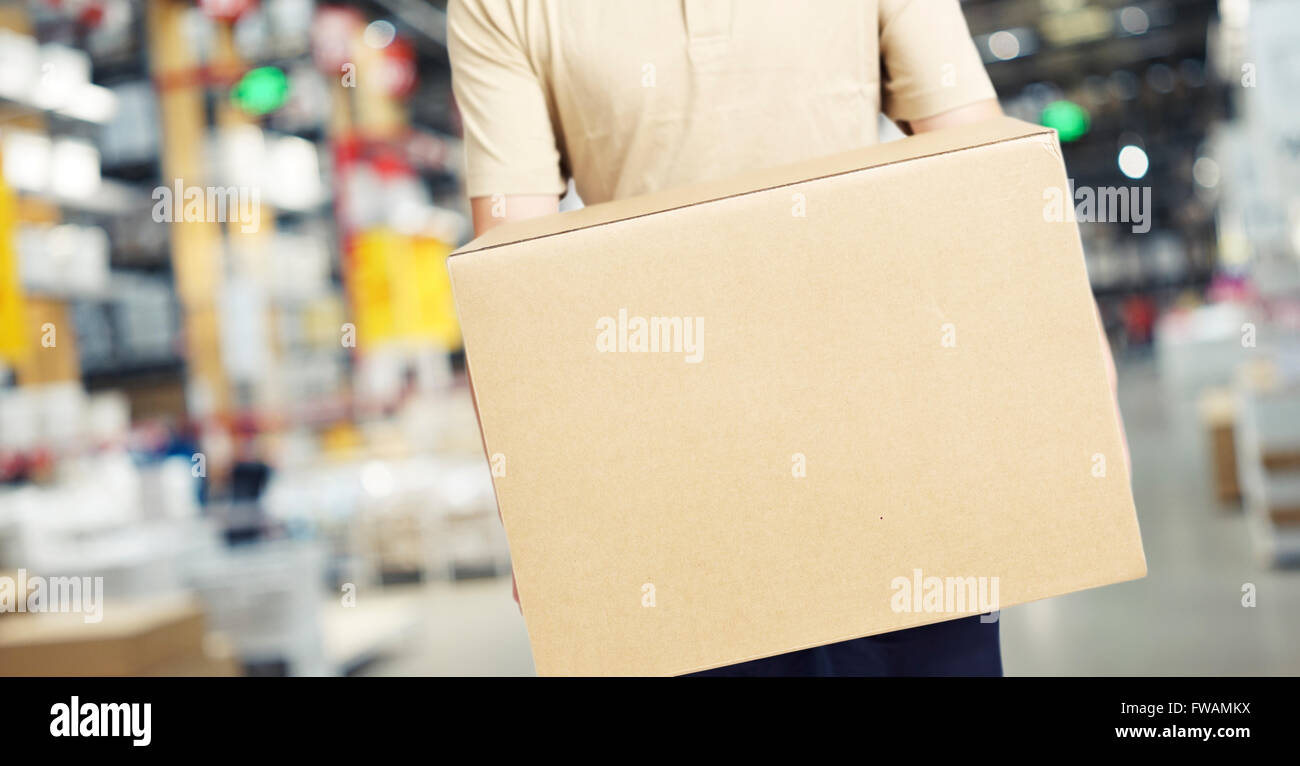 male warehouse worker carrying a large box of goods Stock Photo