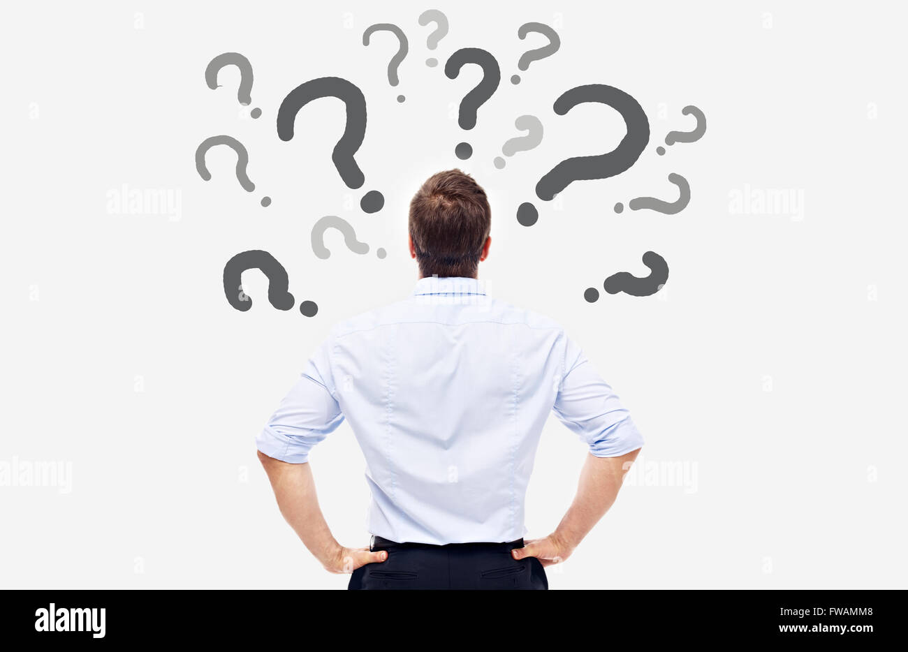 business man looking at the question marks on white board and thinking. Stock Photo