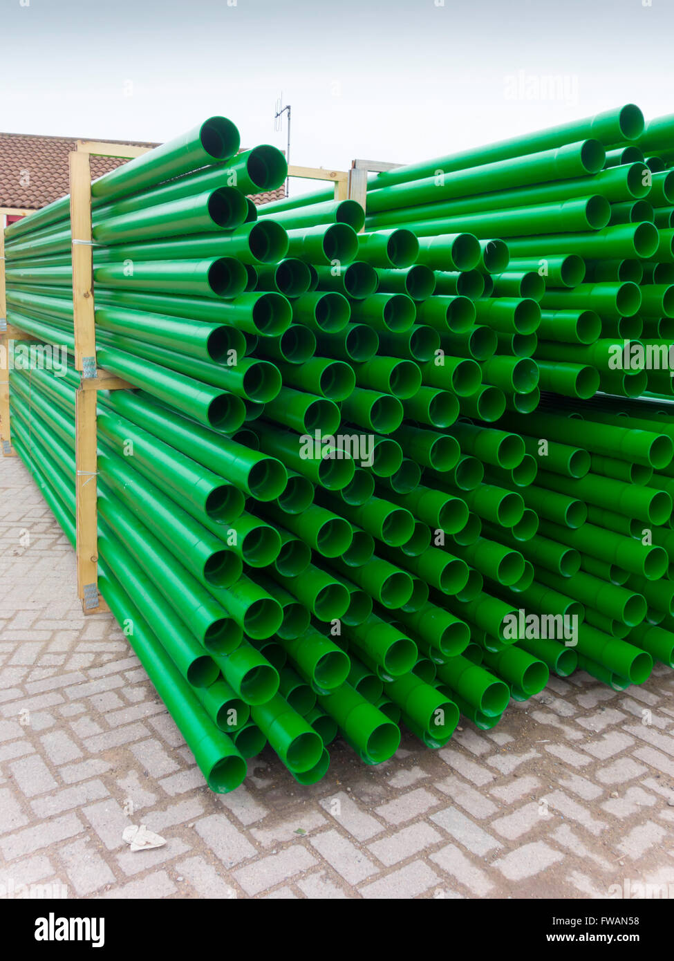 Green plastic pipe with spigot and socket joints delivered in quantity to a work site Stock Photo