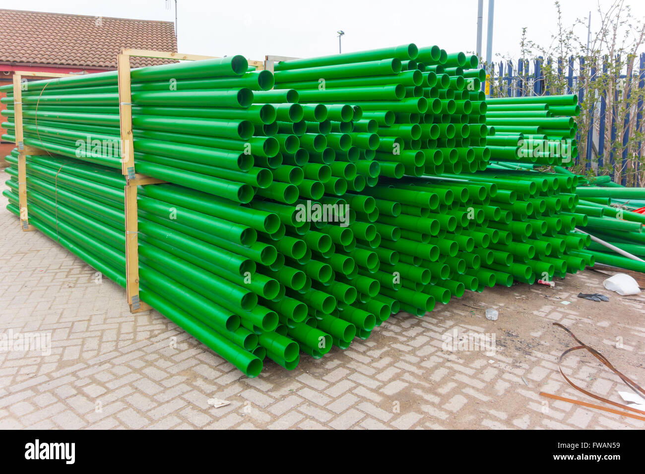 Green plastic pipe with spigot and socket joints delivered in quantity to a work site Stock