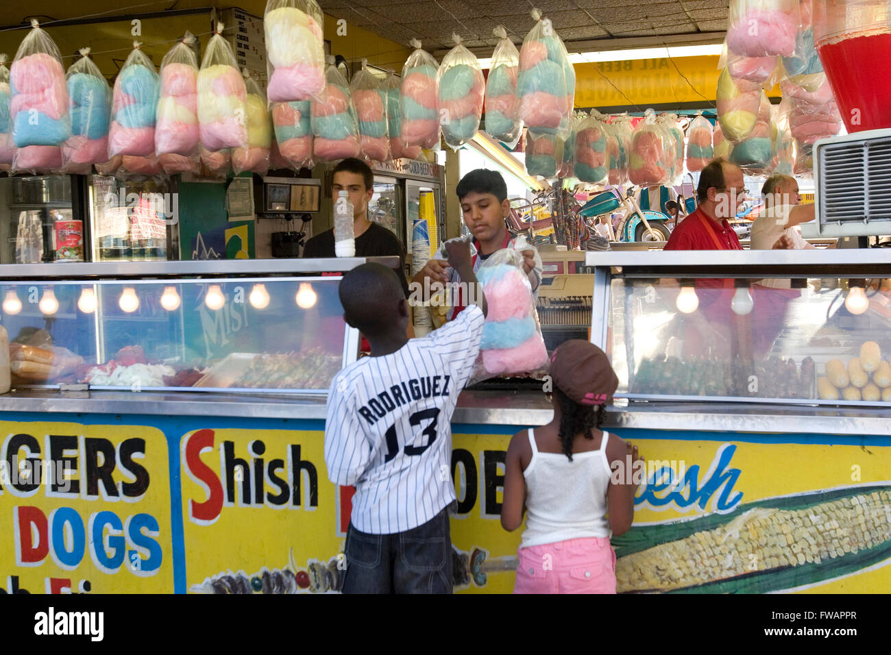 Children buy cotton candy on the boardwalk at a Coney Island 