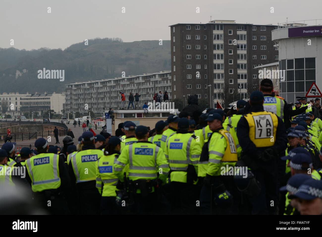 Dover, UK. 2nd April 2016. Clashes As Pro and Anti-refugee groups clash in Dover.  Youths can be seen climbing buildings as police contain protesters on the seafront. Credit: Marc Ward/Alamy Live News Stock Photo