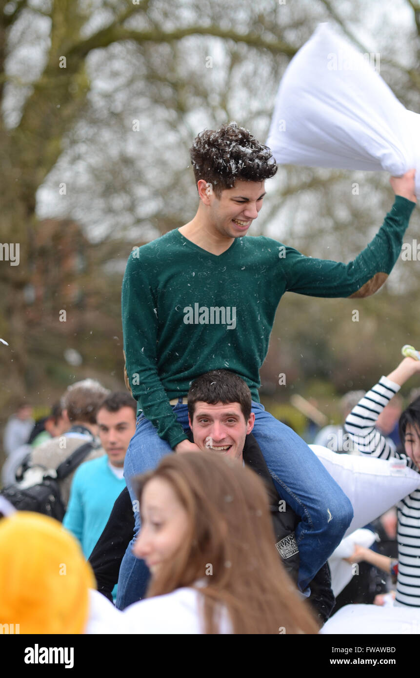 Pillow fight in Kennington Park, London, UK. Hundreds of members of the public brought their own pillows with which to hit each other. Person pillow fighting Stock Photo