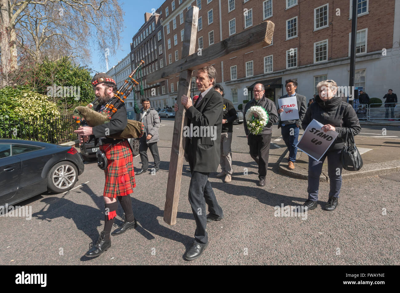 London, UK. 2th April, 2016.  A bagpiper and a man carrying a large cross lead the deputation who hare going to deliver a wreath and petition to the Pakistan High Commission following the Lahore bombing n. Nepalese and British Christians joined with Pakistanis in calling for an end to the blasphemy laws and for the protection of all religious minorities in Pakistan. Peter Marshall/Alamy Live News Stock Photo