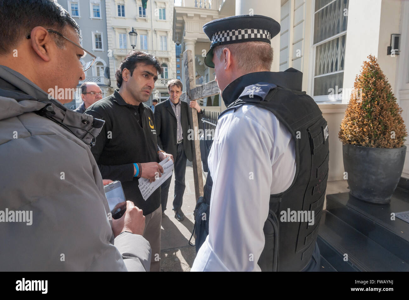 London, UK. 2th April, 2016.  A police officer talks to a Pakistani Christian who is about to deliver a peition to the Pakistan High Commision following the Lahore Easter bombing. The officer made him open the envelope and show the letter before it was delivered. Peter Marshall/Alamy Live News Stock Photo