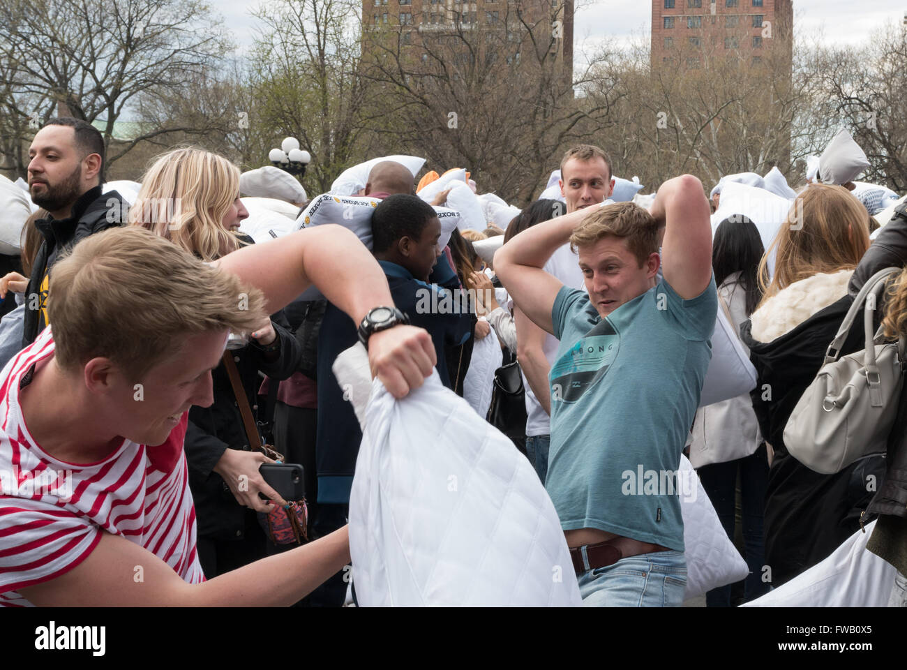 Young men / teenage boys having a pillow fight in Washington Square
