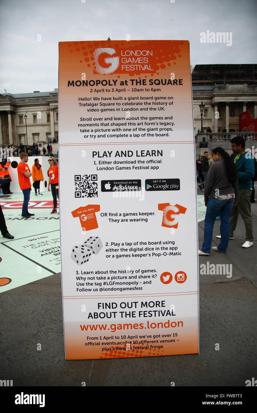 Trafalgar London, London - 3 April 2016 - An information banner about the  London Games Festival. People having fun on a giant 15m sq. Monopoly board  in Trafalgar Square during the London