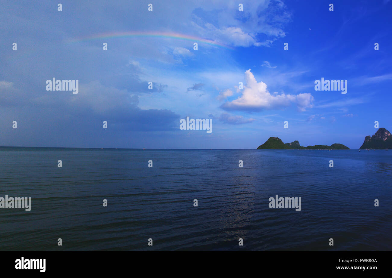landscape view on cloudy sky with colorful rainbow at sea Stock Photo