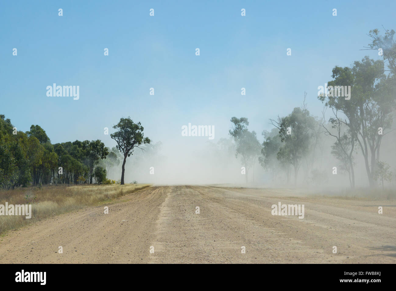 Clouds of dust from a truck driving on outback unsealed road Australia Stock Photo