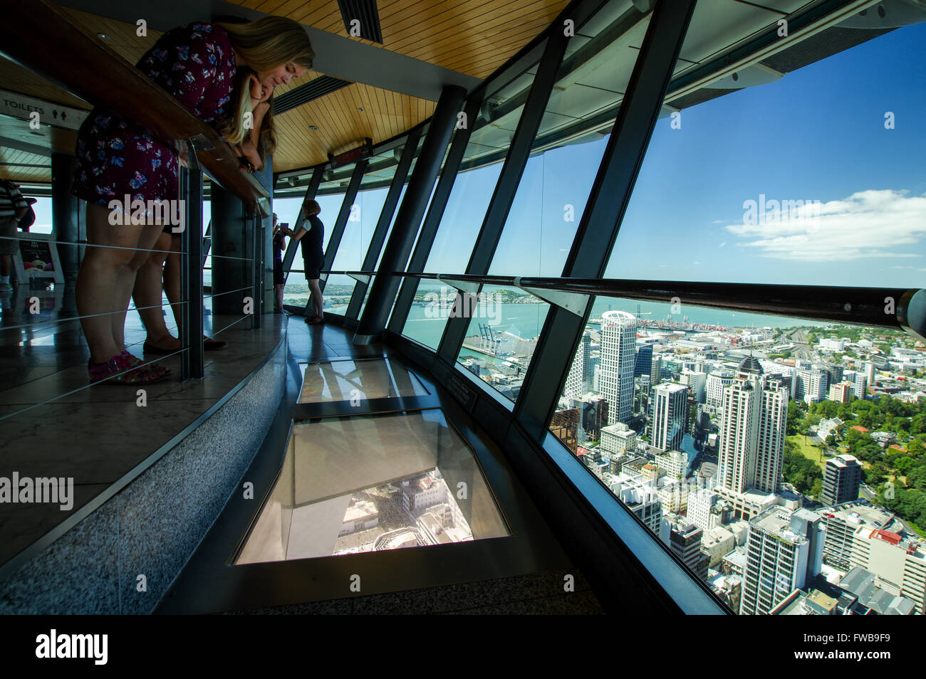 Tourists admiring the view of downtown Auckland from Sky Tower observation deck Stock Photo