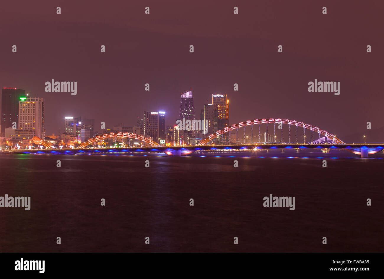 Illuminated Cầu Rồng or dragon bridge over the Han River at night, Da Nang, Central Vietnam, Vietnam Stock Photo