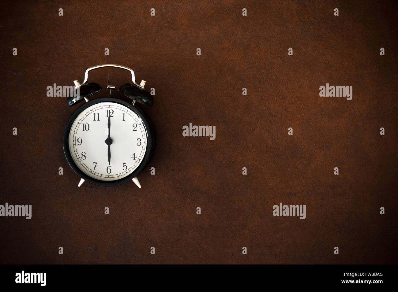Vintage alarm clock reminder symbol on six o'clock hour on wooden background Stock Photo