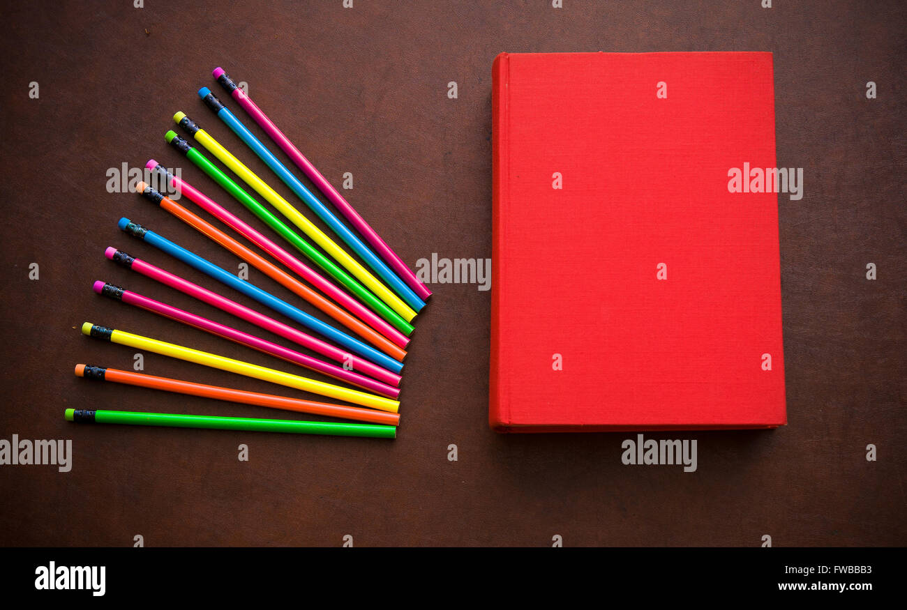 Wooden writer desktop with colorful pencil and red empty cover book Stock Photo