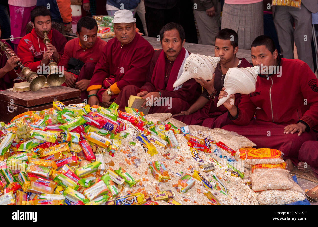 Bodhnath, Nepal.  Tibetan Buddhist Monks Surround Pile of Gifts Given to them on the Tibetan New Year. Stock Photo