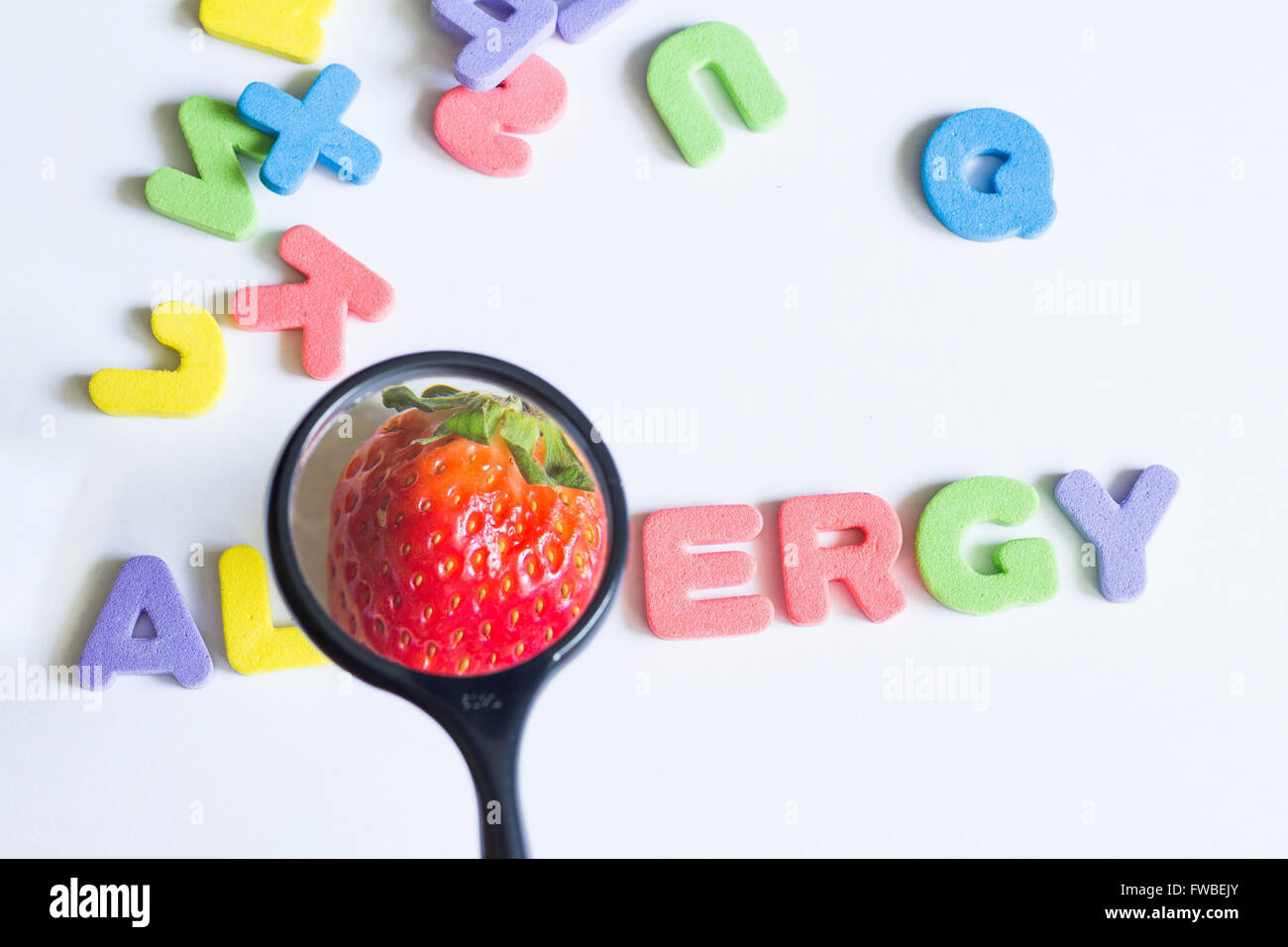 Allergy food strawberry fruit concept with letters and magnifier