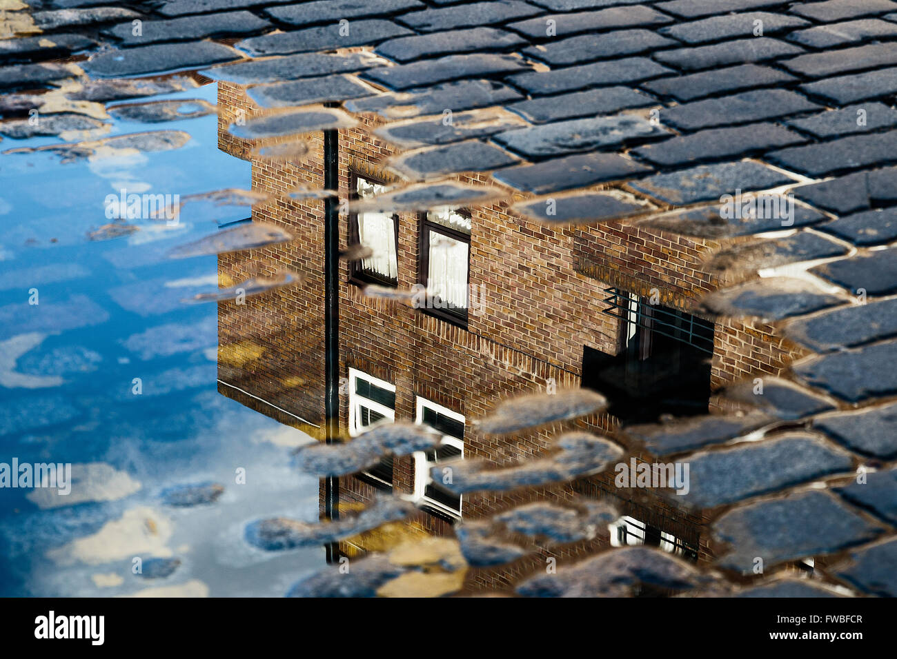 Cobblestone with reflection of house in puddle after rain Stock Photo ...