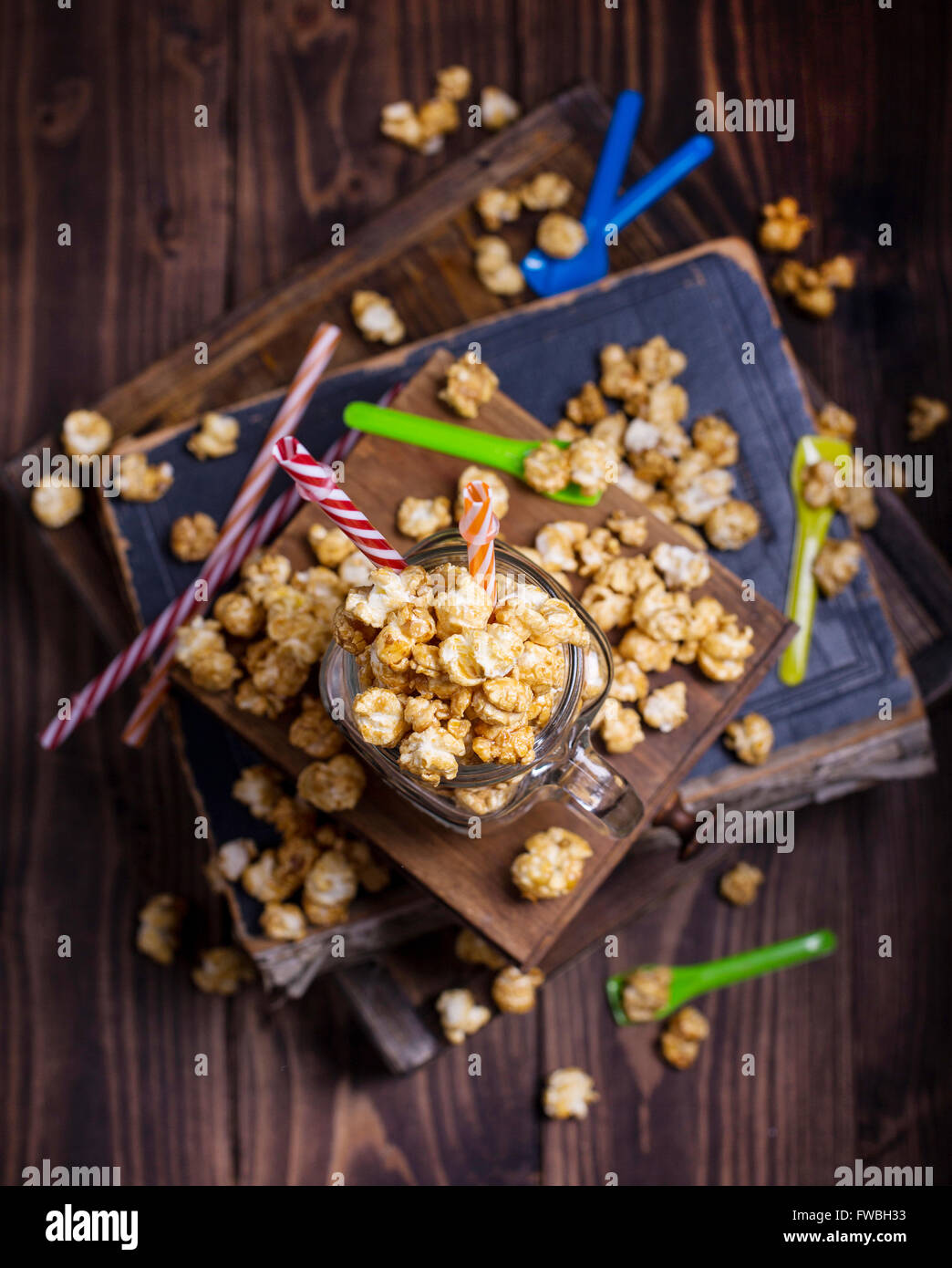 Sweet popcorn with bright colored straws and spoons shot from above